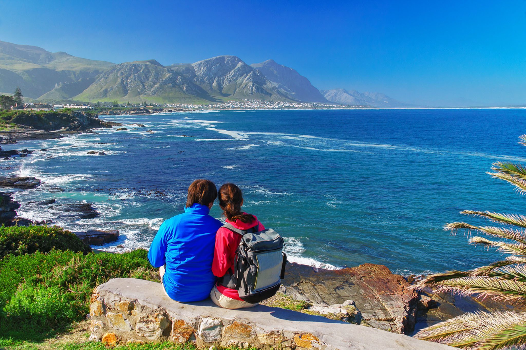 Happy couple looking at beautiful ocean view in Hermanus, while on their romantic getaway near Cape Town